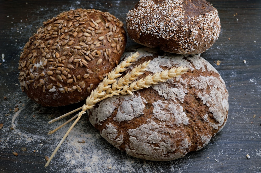 Mains d'un chef pâtissier saupoudrant de la farine et façonnant la pâte sur un plan de travail en bois